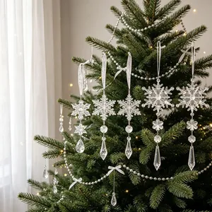 Detail van transparante acryl sneeuwvlok en kristallen hangers aan kerstboom
