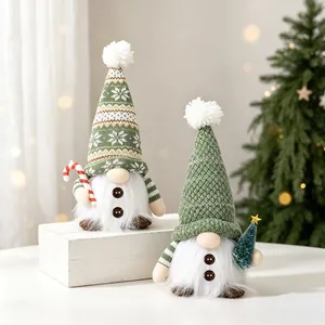 Detailed shot of green knitted Christmas gnomes with white plush beards and candy cane