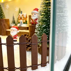 Macro view of a miniature Christmas town scene with a wooden fence and Santa figures