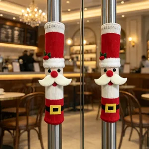 Paire de couvre-poignées tricotés Père Noël sur portes vitrées dans un café chaleureux
