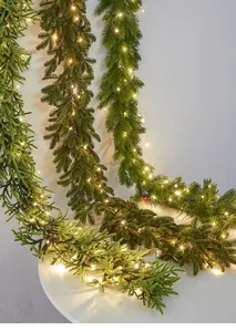 Detailed view of artificial pre-lit Christmas garland with warm white LED lights