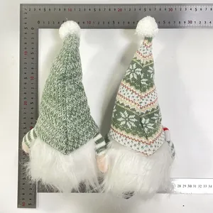 Detail view showing measurements of two green knitted Christmas gnomes with rulers