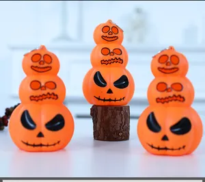 Detailed macro shot of three-tier stacked orange pumpkin LED light ornaments on wood