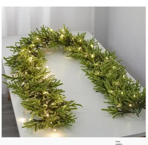 Detailed view of artificial Christmas garland with glowing LED warm white lights