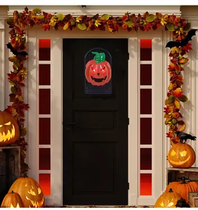 Timbre de calabaza de Halloween con ojos rojos brillantes en una puerta de casa negra
