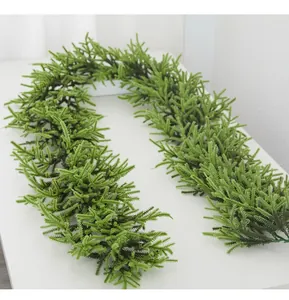 Close-up van een weelderige groene kerstceder slinger op een schoon wit oppervlak