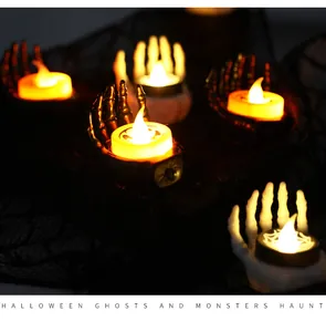 Atmospheric Halloween scene featuring skeletal hand candle holders with glowing LED tealights
