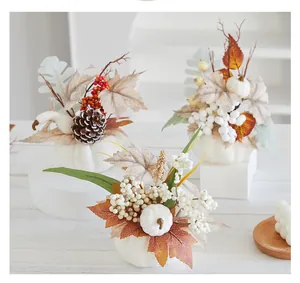 Detailansicht von weißen Schaumkürbis-Ornamenten mit Herbst-Ahornblättern und Beeren.
