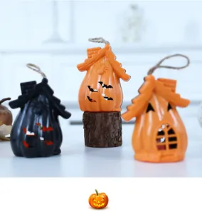 Dettaglio di lanterne a forma di casa zucca di Halloween con intagli di pipistrello e corda
