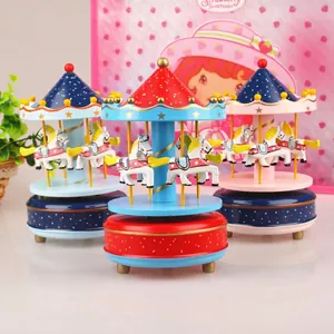 Close-up of colorful handcrafted wooden carousel music boxes in red, blue, and pink tones