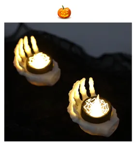 Close-up of Halloween skeleton hand LED candle with glowing spider web light effect