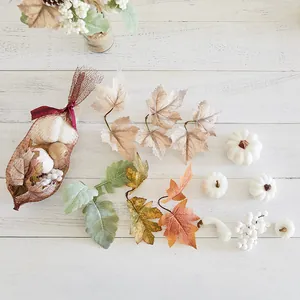 Decorative white artificial pumpkins and autumn maple leaves for Halloween festive displays