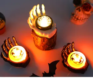 Detail of Halloween skeleton hand candles featuring pumpkin, ghost, and spider web.