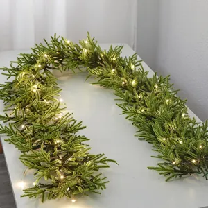 Pre-lit artificial Christmas pine garland with warm LED fairy lights for holiday home wall decor