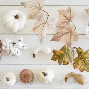 Set of white artificial pumpkins and maple leaves for festive autumn and Halloween decor