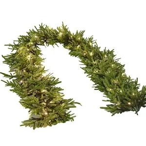 Artificial green Christmas garland with warm white LED fairy lights on white background