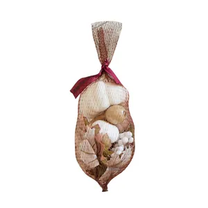 Decorative mesh bag with artificial white pumpkins and autumn maple leaves for Halloween