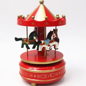 Detailed close-up view of a classic red and gold carousel music box with painted horses