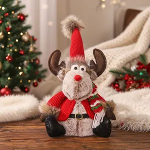Detailansicht einer süßen Rentier-Plüschpuppe mit roter Strickmütze und Schal für Weihnachten