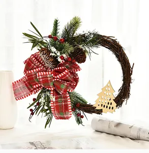 Handmade Christmas twig wreath featuring a red plaid bow and pine cones for decor.