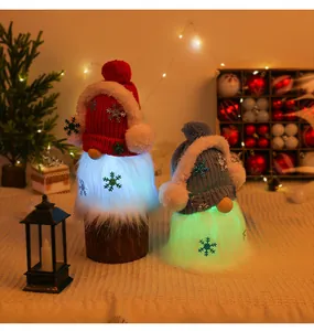 Close-up of Christmas gnomes with glowing LED beards and snowflake knitted hats in festive scene