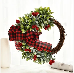 Christmas twig wreath detail with lush greenery, red berries, and buffalo plaid bow