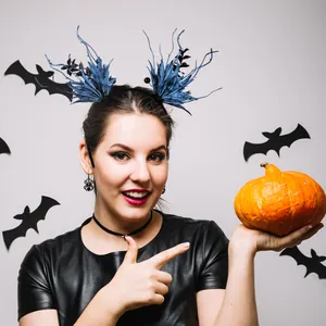 Festive Halloween headband with blue feathered twigs and black bat background decor