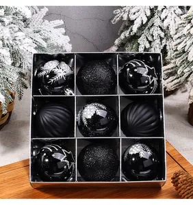 Primo piano di nove palline di Natale nere assortite in una scatola regalo argentata.