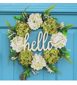 Vista dettagliata di una ghirlanda di ortensie con scritta hello su porta blu
