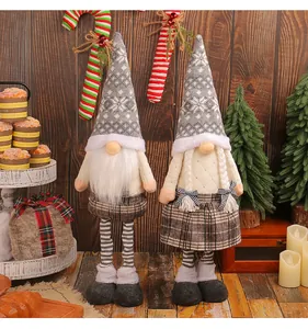 Paire de gnomes de Noël en peluche avec bonnets en tricot sur fond en bois rustique