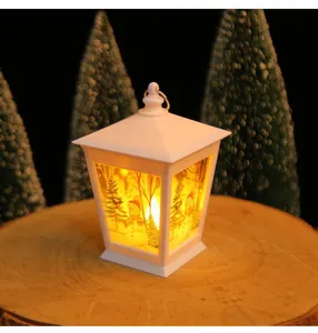 Détail d'une lanterne de Noël blanche avec motif de bonhomme de neige et sapin lumineux.