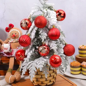Set di palline di Natale rosse festive con motivi di stelle e pini su albero innevato