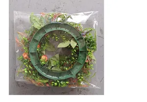Macro detail view showing the back of an artificial autumn foliage wreath in plastic bag.