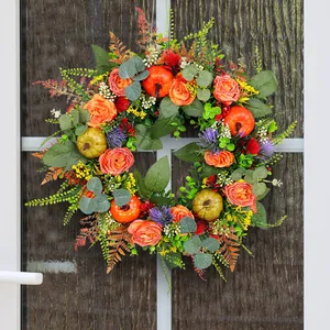 Artificial autumn flower wreath with orange roses and pumpkins for Thanksgiving door decor.