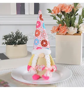 Detailweergave van een schattige kabouterknuffel met een hoed met donutpatroon en vlechtjes.