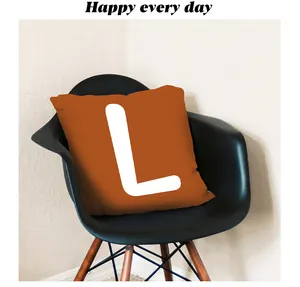 Burnt orange autumn pillowcase featuring a bold white letter L on a modern black chair