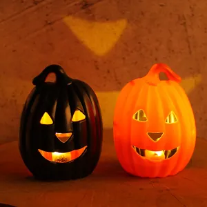 Ein Paar leuchtende Halloween-Kürbis-Laternen in Schwarz und Orange für Festdeko