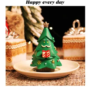 Primo piano di una simpatica statuina di albero di Natale in resina con baffi su un piatto