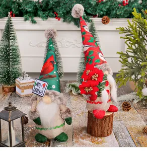 Detailed view of festive plush Christmas gnomes with printed hats and Merry Christmas sign.