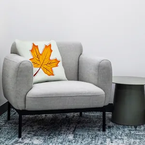 Autumn maple leaf print throw pillow cover displayed on a stylish grey armchair