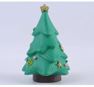 Primo piano di un piccolo albero di Natale in resina verde con stelle e fiocchi di neve