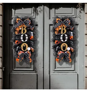 Decorative Halloween 'BOO' wreaths with polka dot bows on a vintage gray double door