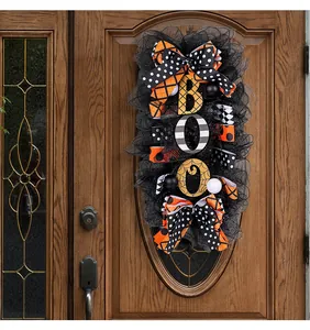 Close-up of a Halloween BOO wreath with orange and black ribbons on a wooden door