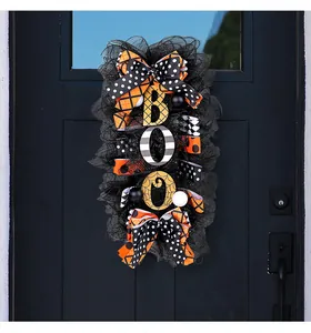 Halloween door wreath detail featuring BOO letters and decorative ribbons on black mesh