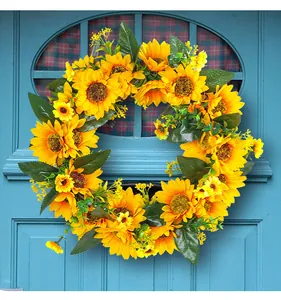 Détail d'une couronne de tournesols jaunes éclatants accrochée à une porte bleue.