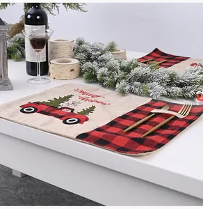 Mantel individual navideño de cuadros rojos y negros con diseño de coche en la mesa.