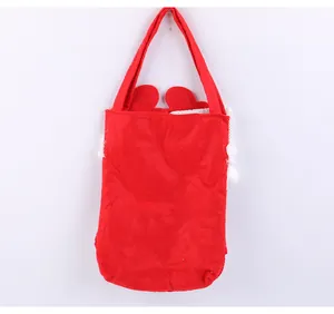 Vue arrière d'un sac cadeau de Noël festif en feutre rouge avec poignée solide et peluche