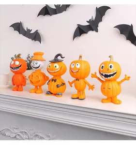 Cinq figurines de citrouilles d'Halloween en résine alignées sur une étagère avec chauve-souris