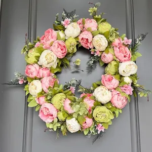 Splendida ghirlanda di peonie primaverili con fiori artificiali rosa per decorare porte.