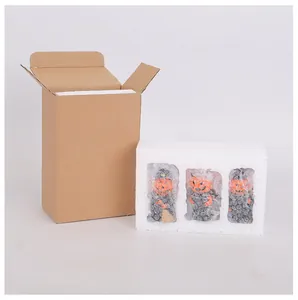 Détail de trois figurines citrouilles d'Halloween emballées dans de la mousse et un carton.